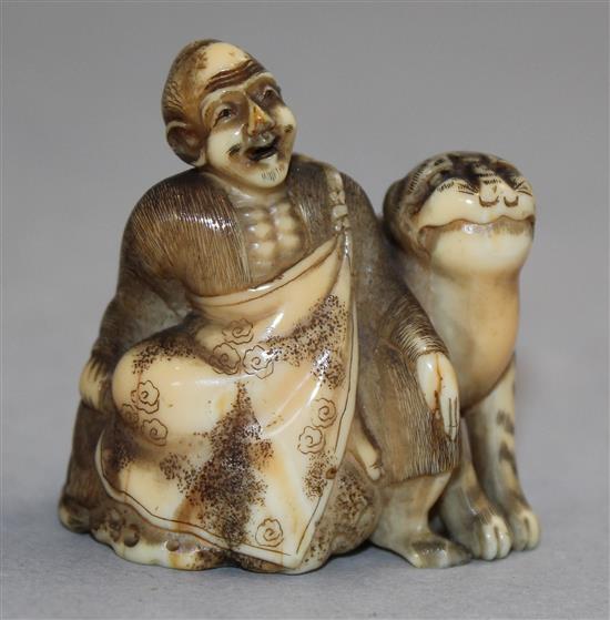 A Japanese walrus ivory netsuke of Binzuru Rakan and a tiger, Meiji period, 4.1cm